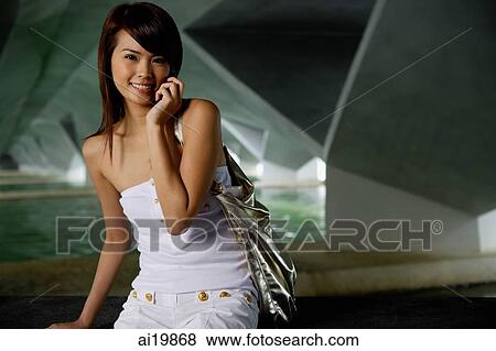 Woman in white tube top using mobile phone View Large Photo Image Stock Photo - Woman in white tube top using mobile phone. Fotosearch