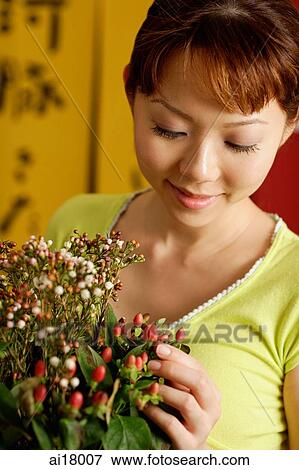 Woman looking at bouquet of flowers View Large Photo Image Stock Photo - Woman looking at bouquet of flowers. Fotosearch