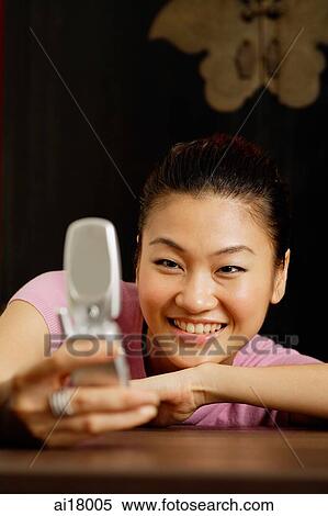 Stock Photography - Woman looking at mobile phone. Fotosearch