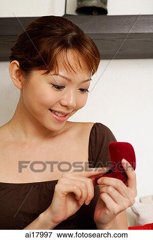 Stock Photo - Woman looking at ring box. Fotosearch