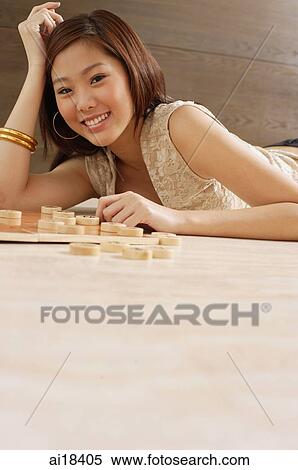 Woman lying on floor, hand on head, Chinese chess pieces on floor next to her View Large Photo Image Stock Photography - Woman lying on floor, hand on head, Chinese chess pieces on floor next to her. Fotosearch