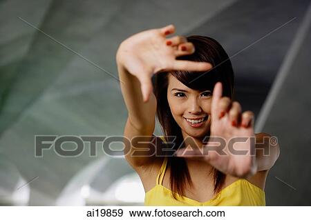 Woman making finger frame, smiling at camera View Large Photo Image Stock Photo - Woman making finger frame, smiling at camera. Fotosearch