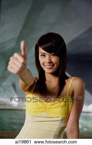 Woman making thumbs-up sign, smiling View Large Photo Image Stock Image - Woman making thumbs-up sign, smiling. Fotosearch