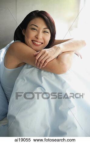 Woman on bed hugging knees, arms crossed View Large Photo Image Stock Photography - Woman on bed hugging knees, arms crossed. Fotosearch