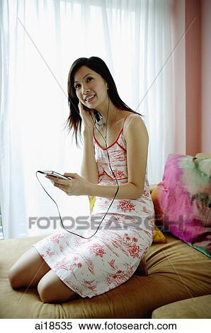 Woman on bed, listening to MP3 player View Large Photo Image Stock Photography - Woman on bed, listening to MP3 player. Fotosearch