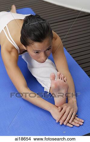 Woman on yoga mat, stretching View Large Photo Image Picture - Woman on yoga mat, stretching. Fotosearch