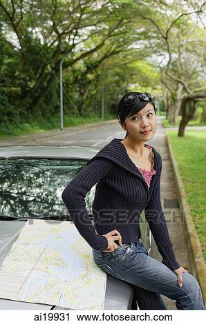 Woman sitting on hood of car, map next to her View Large Photo Image Stock Image - Woman sitting on hood of car, map next to her. Fotosearch