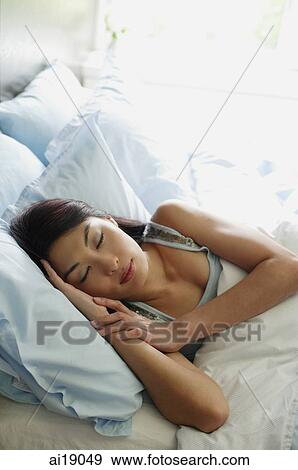 Stock Photo - Woman sleeping in bedroom. Fotosearch