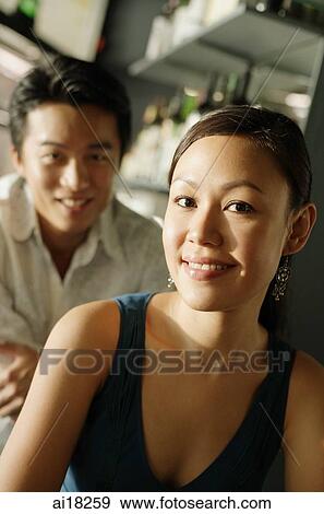 Woman smiling at camera, man in the background, smiling View Large Photo Image Stock Photo - Woman smiling at camera, man in the background, smiling. Fotosearch