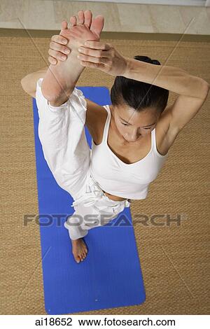 Woman standing on one leg, holding foot, stretching View Large Photo Image Stock Image - Woman standing on one leg, holding foot, stretching. Fotosearch