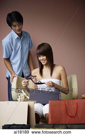 Woman surrounded by shopping bags, looking at shoe, man standing behind her View Large Photo Image Stock Photo - Woman surrounded by shopping bags, looking at shoe, man standing behind her. Fotosearch