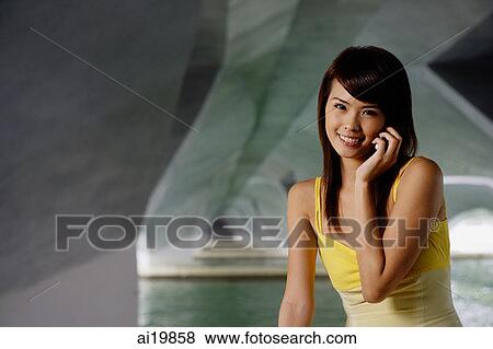 Woman using mobile phone, smiling View Large Photo Image Stock Photo - Woman using mobile phone, smiling. Fotosearch