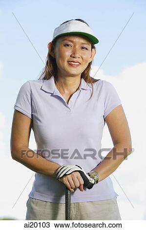 Woman wearing sun visor, leaning on golf club View Large Photo Image Stock Image - Woman wearing sun visor, leaning on golf club. Fotosearch