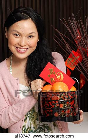 Woman with basket of oranges and red packet View Large Photo Image Stock Photo - Woman with basket of oranges and red packet. Fotosearch