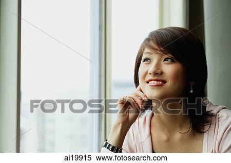 Stock Photography - Woman with hand on chin, looking away. Fotosearch