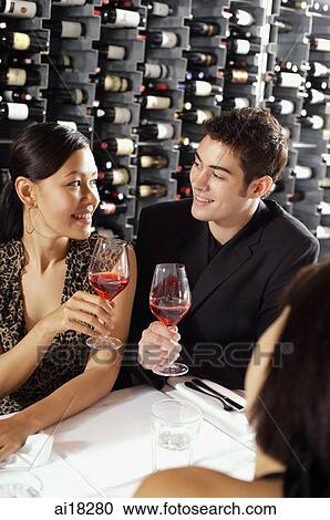 Young adults in restaurant, holding wine glasses View Large Photo Image Stock Image - Young adults in restaurant, holding wine glasses. Fotosearch