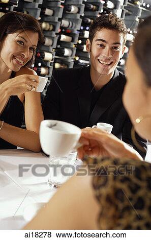 Young adults sitting in restaurant, having coffee View Large Photo Image Stock Photo - Young adults sitting in restaurant, having coffee. Fotosearch