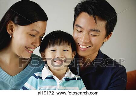 Young boy between mother and father, smiling at camera View Large Photo Image Stock Image - Young boy between mother and father, smiling at camera. Fotosearch