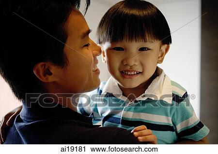 Young boy carried by dad, looking at camera View Large Photo Image Stock Image - Young boy carried by dad, looking at camera. Fotosearch