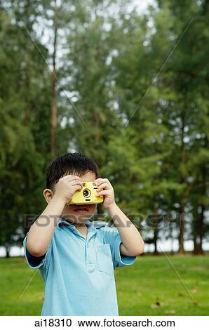 Young boy in park using camera View Large Photo Image Stock Image - Young boy in park using camera. Fotosearch