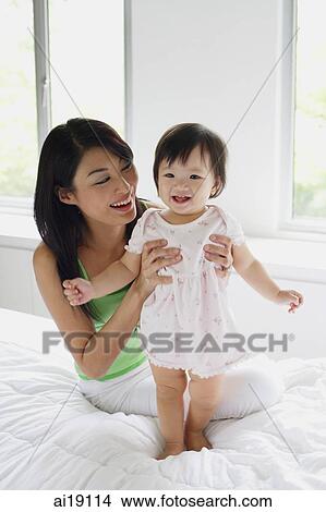 Young girl standing, mother supporting her View Large Photo Image Picture - Young girl standing, mother supporting her. Fotosearch