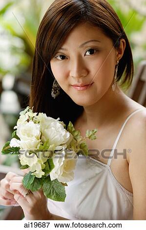 Young woman holding a bouquet of flowers, portrait View Large Photo Image Stock Photo - Young woman holding a bouquet of flowers, portrait. Fotosearch