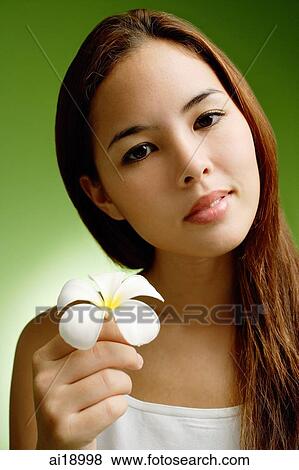 Young woman holding Frangipani flower View Large Photo Image Stock Photo - Young woman holding Frangipani flower. Fotosearch