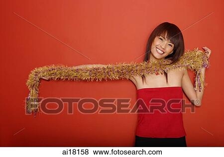 Young woman in red tube top holding feather boa View Large Photo Image Stock Photo - Young woman in red tube top holding feather boa. Fotosearch