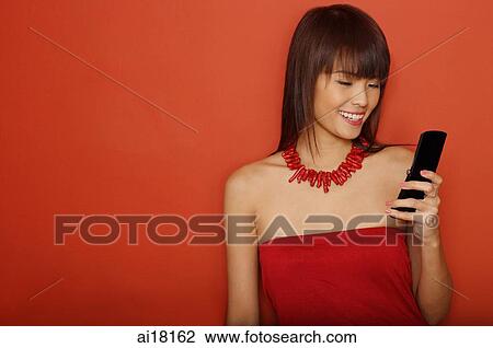 Young woman in red tube top using mobile phone View Large Photo Image Stock Image - Young woman in red tube top using mobile phone. Fotosearch
