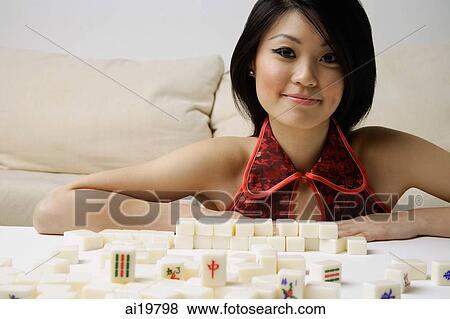 Young woman looking at camera, mahjong tiles on table in front of her View Large Photo Image Stock Photo - Young woman looking at camera, mahjong tiles on table in front of her. Fotosearch