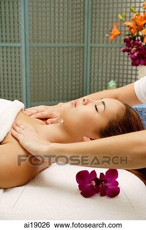 Young woman lying on back, having shoulders massaged View Large Photo Image Stock Photograph - Young woman lying on back, having shoulders massaged. Fotosearch