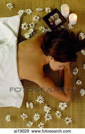 Young woman lying on floor, flowers on floor around her, high angle view View Large Photo Image Stock Photo - Young woman lying on floor, flowers on floor around her, high angle view. Fotosearch