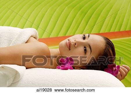 Young woman lying on massage table View Large Photo Image Stock Photo - Young woman lying on massage table. Fotosearch