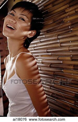 Young woman next to bamboo screen, smiling View Large Photo Image Stock Photograph - Young woman next to bamboo screen, smiling. Fotosearch