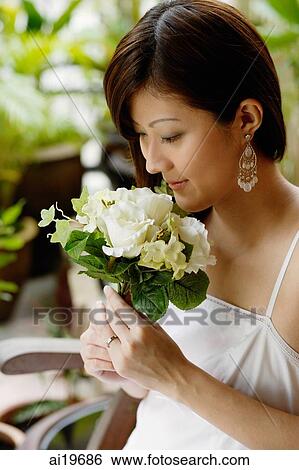 Young woman smelling bouquet of flowers View Large Photo Image Stock Photograph - Young woman smelling bouquet of flowers. Fotosearch