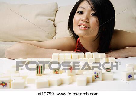 Young woman smiling at camera, mahjong tiles on table in front of her View Large Photo Image Stock Photo - Young woman smiling at camera, mahjong tiles on table in front of her. Fotosearch
