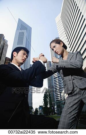 Stock Photography - A businessman and a businesswoman fight in the city. Fotosearch