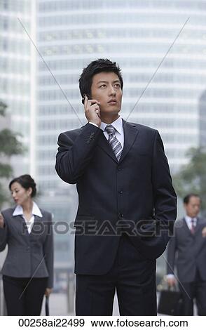 Stock Photo - A businessman uses his cellphone. Fotosearch