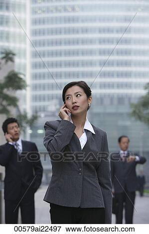 Stock Photo - A businesswoman uses her cellphone. Fotosearch