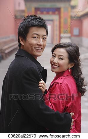 A couple hug and smile as they look at the camera View Large Photo Image Stock Photo - A couple hug and smile as they look at the camera. Fotosearch