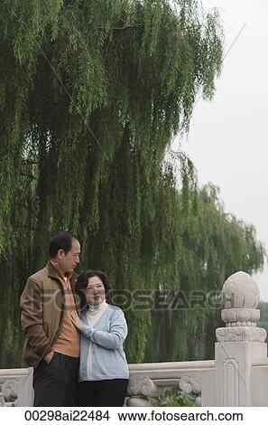 A couple hug as they stand outside View Large Photo Image Picture - A couple hug as they stand outside. Fotosearch