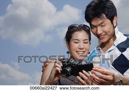 Stock Photo - A couple look at the photos they have taken. Fotosearch