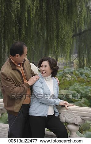 A couple smile at each other as they stand outside View Large Photo Image Stock Photo - A couple smile at each other as they stand outside. Fotosearch