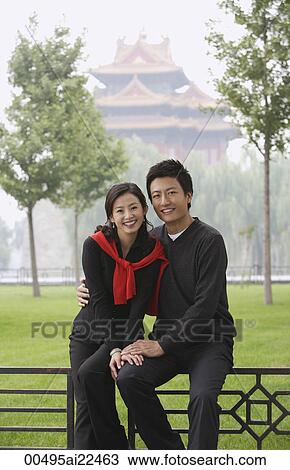Stock Image - A couple smile at the camera as they in front of The Forbidden City, Beijing. Fotosearch
