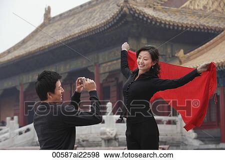 Stock Photo - A couple take photos of each other in front of The Forbidden City, Beijing. Fotosearch