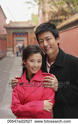 Stock Photo - A couple with their arms around each other. Fotosearch