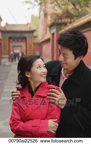 Stock Photograph - A couple with their arms around each other. Fotosearch