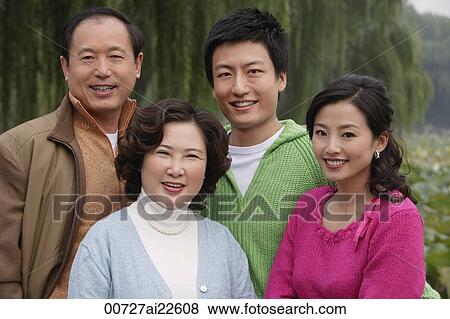 Stock Photo - A family look at the camera as they pose for photos together while on vacation. Fotosearch