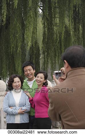 A family pose for photos together while on vacation View Large Photo Image Stock Image - A family pose for photos together while on vacation. Fotosearch