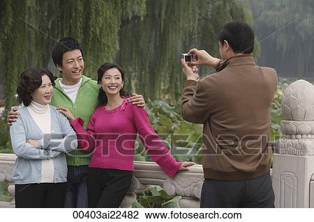 Stock Image - A family pose for photos together while on vacation. Fotosearch